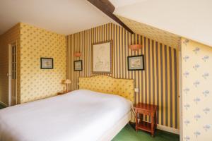 - une chambre avec un lit et un mur rayé dans l'établissement Castel Novel Cottage, à Varetz