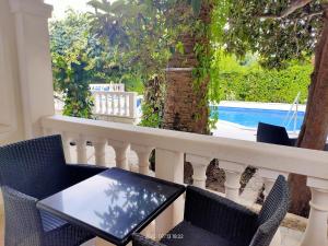 a table and chairs on a balcony with a view of a pool at Villa Artpalathos in Kaštela