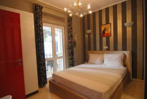 a bedroom with a bed and a window and a chandelier at Villa Artpalathos in Kaštela