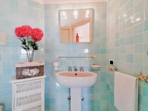 Un baño con azulejos azules, lavabo y espejo. en Porto Cervo Residence Vistamare, en Porto Cervo 47 fotos más