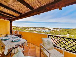 Un comedor con mesa y sillas en un balcón. en Porto Cervo Residence Vistamare, en Porto Cervo