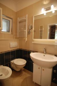 a bathroom with a sink and a toilet and a mirror at Villa Artpalathos in Kaštela
