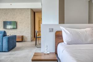 a bedroom with a bed and a blue couch at Cozy Apartment Heart of St Julians Sleeps 5 in San Pawl il Bahar