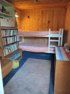 a room with two bunk beds and a book shelf at Veski talu aidamaja 