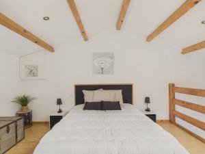 a bedroom with a large white bed in a room with wooden beams at Belle et spacieuse maison au calme pour 8 in Saint-Révérend