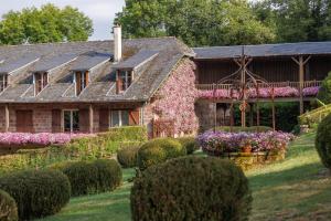 une vieille maison avec des fleurs dans la cour dans l'établissement Castel Novel Cottage, à Varetz