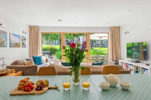 a living room with a table with a vase of flowers at House 6 in Looe