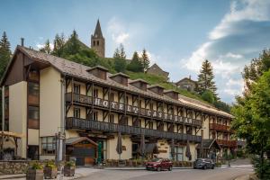 een groot gebouw met een kerk op de top van een heuvel bij Hotel Castillan in La Grave