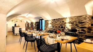 a restaurant with tables and chairs and a stone wall at MoselVilla No 7 in Pommern