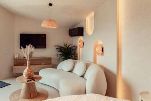 a living room with a white chair and a tv at Amumi Lacul Bicaz - Casuta Infinity in Buhalniţa