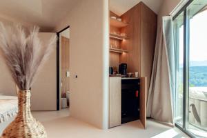 a bedroom with a vase in a room with a window at Amumi Lacul Bicaz - Casuta Infinity in Buhalniţa