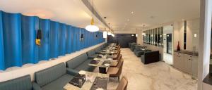 a row of tables in a restaurant with blue walls at Orchard Bliss in Bhopal