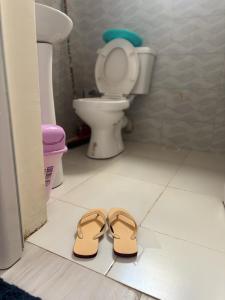 a pair of shoes in a bathroom with a toilet at Bukoto Stays 1 Bedroom Apartment in Kampala