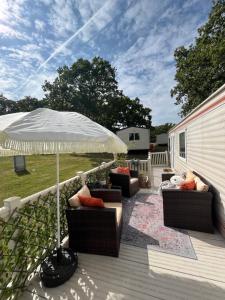 a patio with two chairs and an umbrella on a deck at The Van in Porchfield