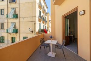 a balcony with a table and chairs on a building at Jolanda Sea Breeze in Trapani