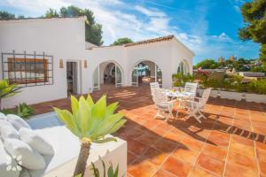 a patio with a table and chairs on a house at Villa Buenos Aires by Abahana Villas in Rada de Moraira