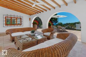 a patio with wicker furniture and a table and chairs at Villa Buenos Aires by Abahana Villas in Rada de Moraira