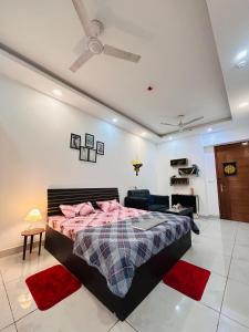 a bedroom with a bed and a ceiling fan at Naples Suite - Green Facing Park View in Noida