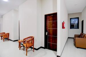 a room with a door and chairs and a couch at Hotel O Balikpapan near Siloam Hospital formerly Syafla Guest House in Balikpapan