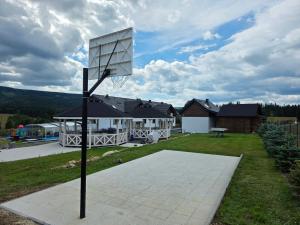 a basketball hoop in the backyard of a house at Jagodowy Ski&Spa pensjonat z widokiem na góry,podgrzewany basen zewnętrzny latem,bilard,świetne Wi-Fi,Restauracja,balia,sauna na miejscu in Lasowka