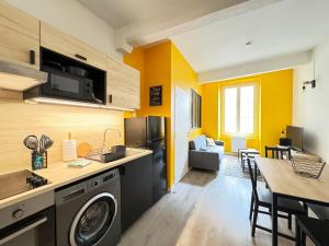 a kitchen and living room with yellow walls at T2 Centre Riom 3 Personnes in Riom