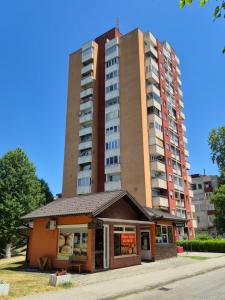 ein hohes Wohnhaus mit einer Konditorei davor in der Unterkunft Apartman Pasarela - mirna lokacija u centru in Bihać + 10 Fotos