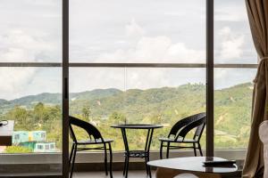 two chairs and a table in front of a window at Serene Japandi Family Retreat 2-6 pax& Sunrise View in Brinchang