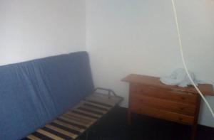 sypialnia z niebieskim łóżkiem i drewnianą komodą w obiekcie Hostel Orotava w mieście La Orotava