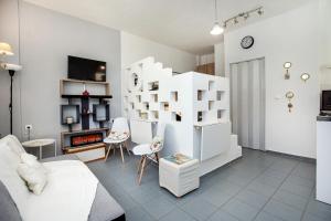 a living room with white furniture and a fireplace at Sun Ray Apartments Thassos in Limenas