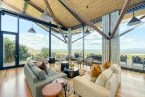 a living room with large windows and couches at Grootbos Private Nature Reserve in Gansbaai