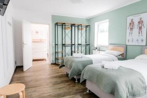 a room with three beds with green walls at janu-homes - 2 Zimmer Apartment - 4 Betten, Lahnblick vom Amselweg in Runkel
