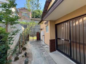 an empty alleyway between two buildings with a fence at MINI HOTEL totonoi ロウリュ式サウナのある静かな平屋 in Shimonoseki