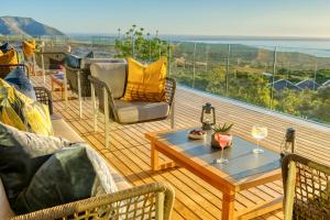 a balcony with a table and chairs and a view of the ocean at Grootbos Private Nature Reserve in Gansbaai