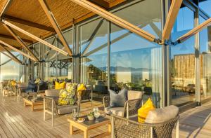 an outdoor patio with couches and tables and windows at Grootbos Private Nature Reserve in Gansbaai