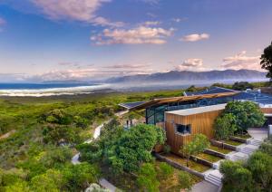 an aerial view of a house with mountains in the background at Grootbos Private Nature Reserve in Gansbaai