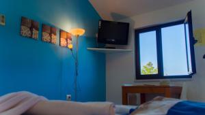 a room with a blue wall with a lamp and a tv at VIScovery Boutique in Rukavac +65 photos