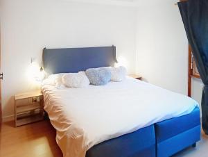 une chambre avec un lit avec une tête de lit bleue dans l'établissement Week End 3, à Verbier