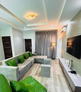 a living room with a couch and a tv at Nook & Cranny apartment jahi, abuja in Mama