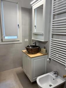 a bathroom with a sink and a mirror and a sink at Mazzini Stay in Gorizia +14 photos