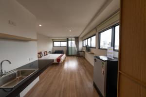 a kitchen with a sink and a bed in a room at L.A. Tower Hotel in Bangkok
