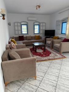 a large living room with couches and a table at Villa FTIMA in Mezraya