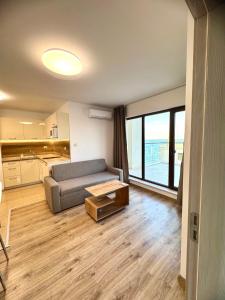 a living room with a couch and a table at Cabacum Pleasure Beachfront Apartments in Varna City