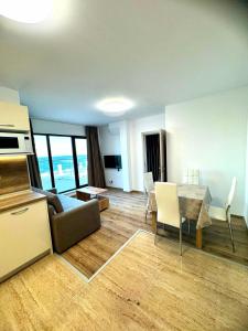 a living room with a couch and a table at Cabacum Pleasure Beachfront Apartments in Varna City