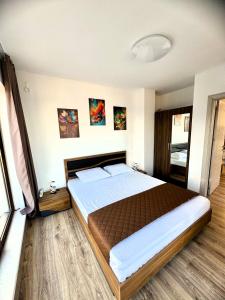 a bedroom with a large bed in a room at Cabacum Pleasure Beachfront Apartments in Varna City +7 photos