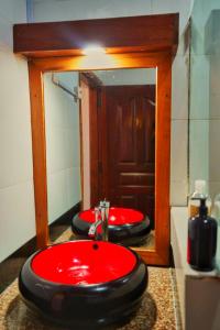 a bathroom with two red sinks and a mirror at Ocean Breeze Apartments,Shanzu in Mombasa