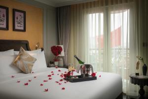 a bedroom with a bed with flowers on it at La Mejor Indochine Hotel in Hanoi +109 photos