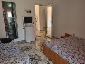 a bedroom with a bed and a tv on a refrigerator at Casa Natalia in Eforie Nord