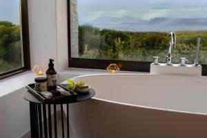 a bath tub in a bathroom with a large window at Grootbos Private Nature Reserve in Gansbaai