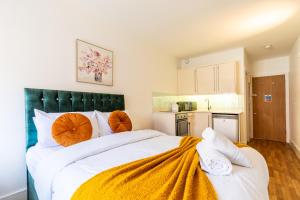 a bedroom with a large bed with orange pillows at Kensington Luxury Suites in London +26 photos
