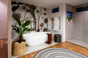 a bathroom with a bath tub with a plant at Grootbos Private Nature Reserve in Gansbaai